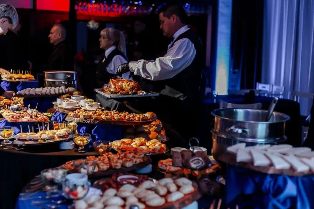 Mesa de catering con gastronomía de autor servida por mozos en un evento de Eclipse Eventos