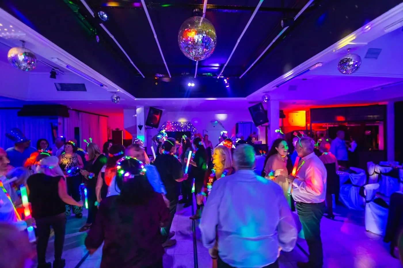 Pista de baile iluminada con disco balls y accesorios luminosos en un evento de Eclipse Eventos