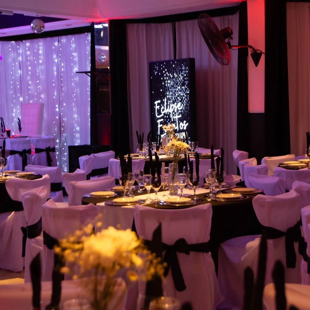 Salón Eclipse Eventos con mesas puestas y letrero luminoso, listo para tu evento