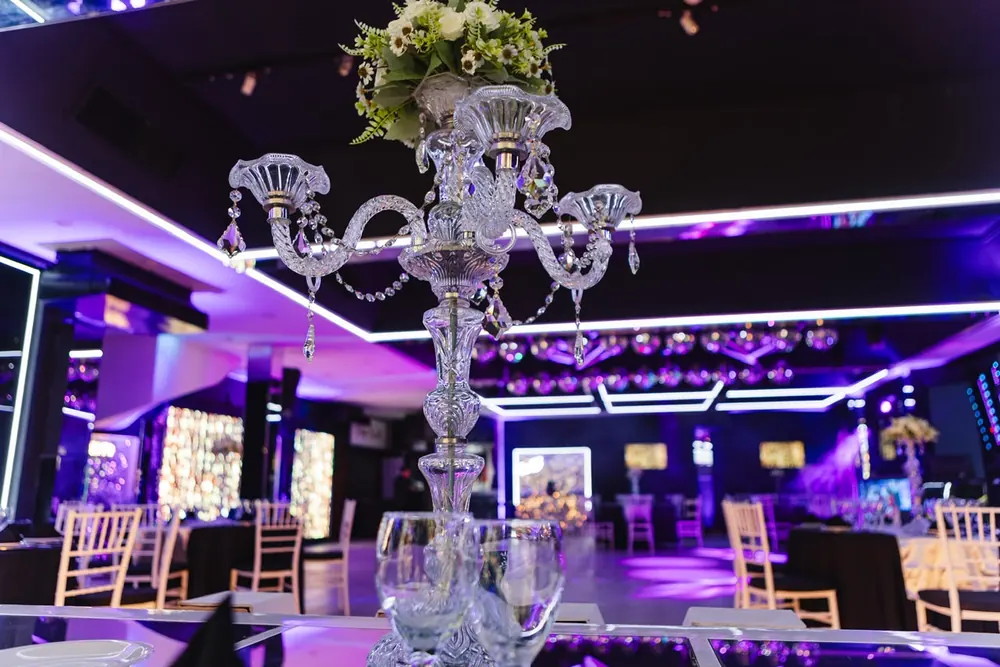 Candelabro de cristal sobre mesa principal con vista al salón de Eclipse Eventos