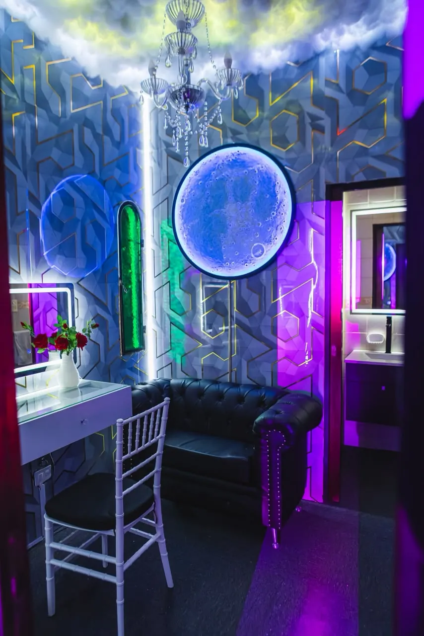 Lounge privado con temática lunar, candelabro de cristal y sillón de cuero en Eclipse Eventos